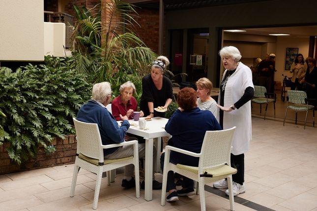 Residents chat in the courtyard of Uniting The Garrison