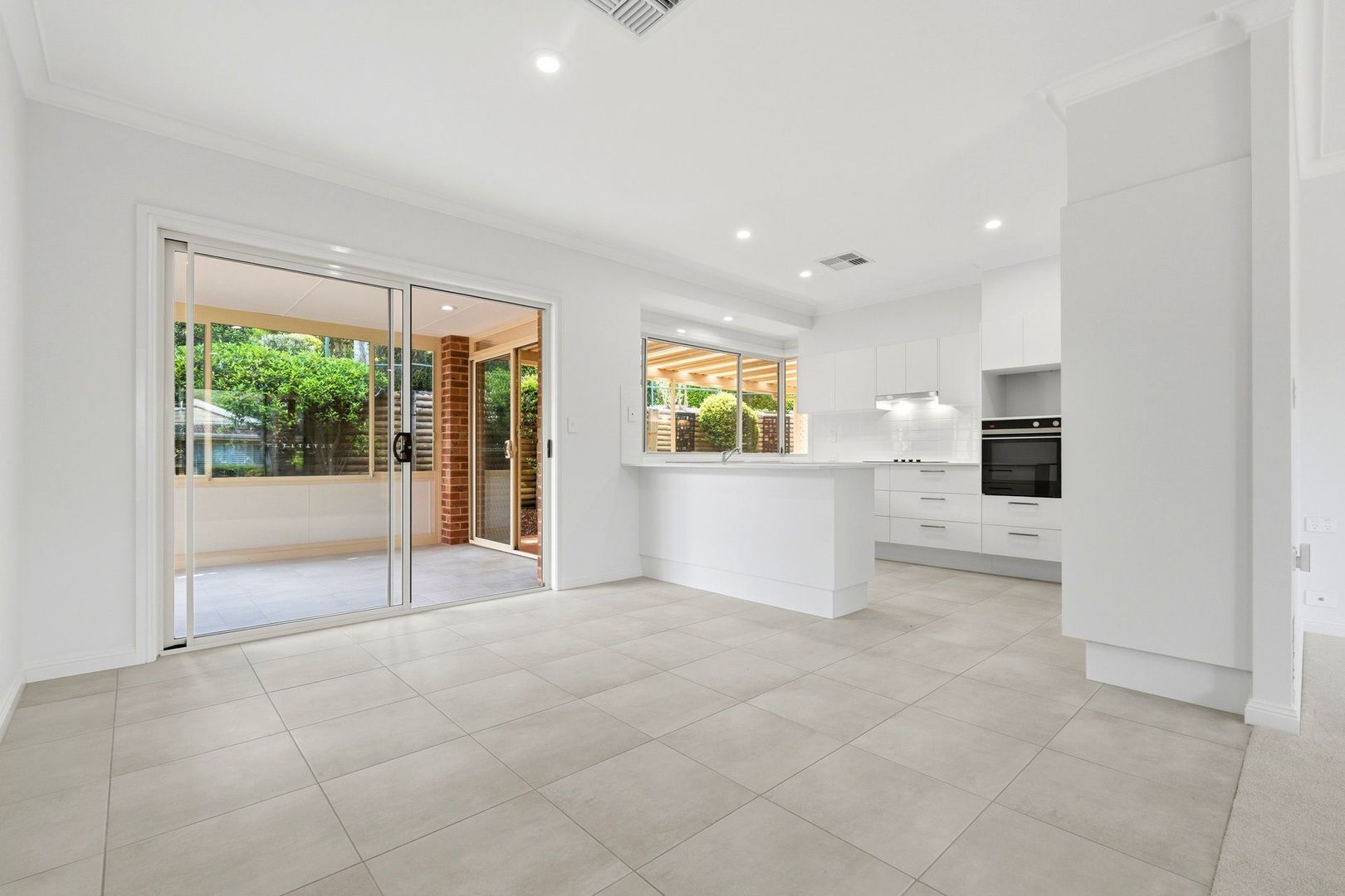 East facing rear aspect with enclosed sunroom and patio area for entertaining